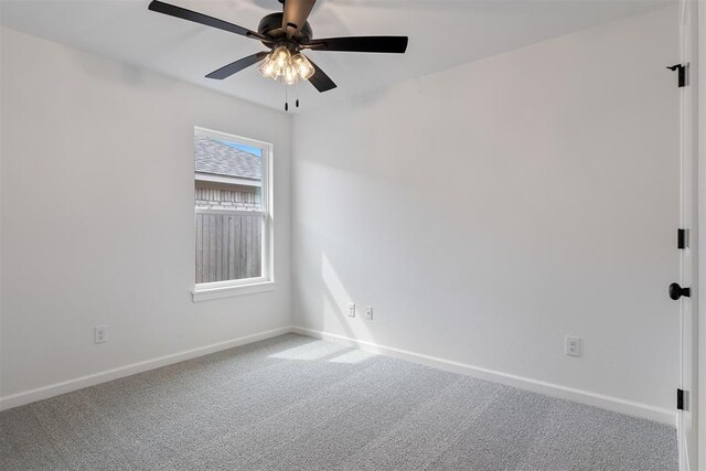 carpeted empty room with a ceiling fan and baseboards