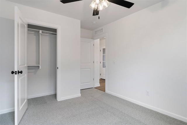 unfurnished bedroom featuring a ceiling fan, carpet, visible vents, baseboards, and a closet