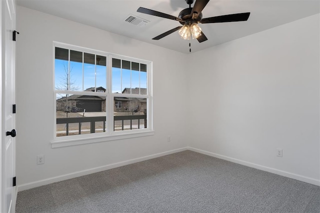 carpeted spare room featuring visible vents, baseboards, and a ceiling fan