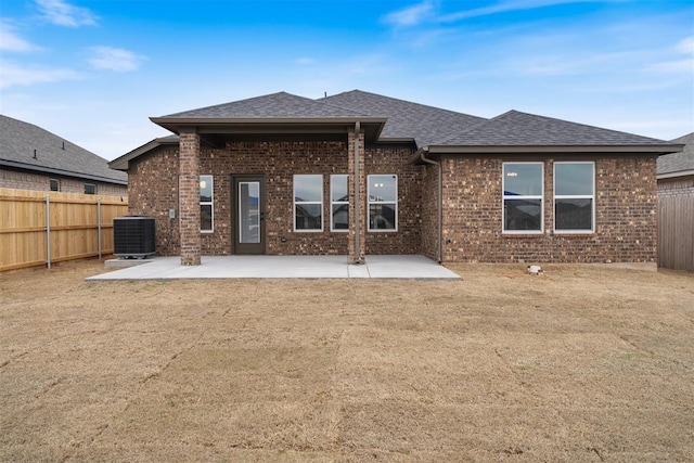 back of house with a patio, brick siding, central AC, and a fenced backyard