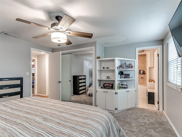 bedroom with connected bathroom, light colored carpet, a closet, and a textured ceiling