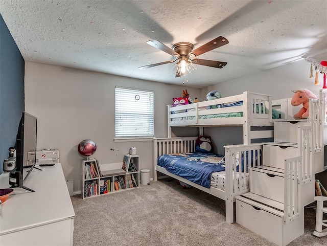 carpeted bedroom featuring ceiling fan and a textured ceiling