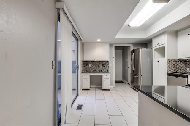 kitchen featuring tasteful backsplash, appliances with stainless steel finishes, light tile patterned floors, and white cabinets