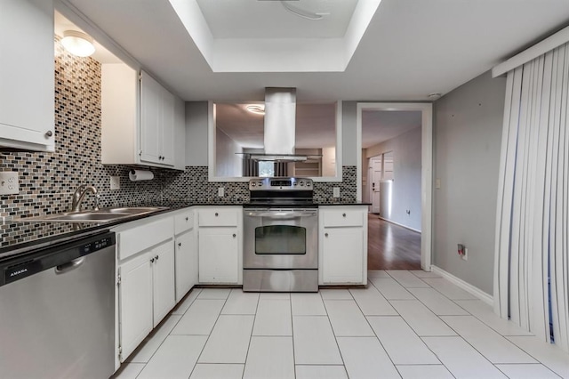 kitchen featuring sink, white cabinets, island exhaust hood, stainless steel appliances, and backsplash