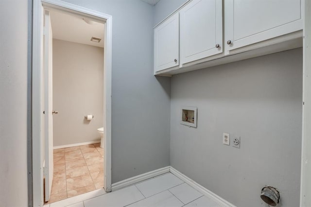 clothes washing area featuring cabinets, light tile patterned flooring, washer hookup, and hookup for an electric dryer