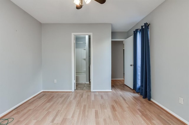 unfurnished bedroom with a spacious closet, light hardwood / wood-style flooring, and ceiling fan