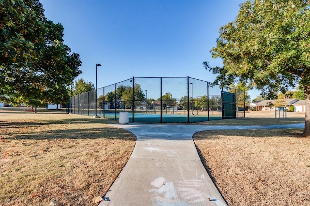 view of home's community with tennis court and a lawn