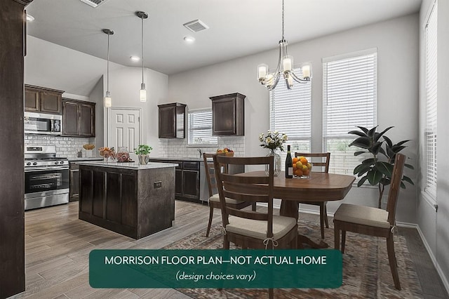 kitchen featuring hanging light fixtures, dark brown cabinets, a center island, and appliances with stainless steel finishes