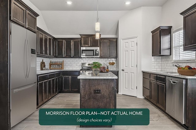 kitchen with pendant lighting, appliances with stainless steel finishes, dark brown cabinets, a kitchen island, and light wood-type flooring