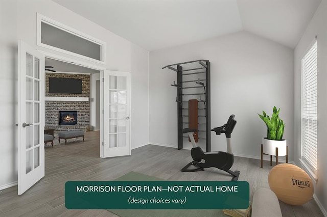 workout room featuring french doors, lofted ceiling, a fireplace, and hardwood / wood-style floors