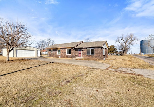 view of front of house featuring a garage, an outbuilding, and a front yard