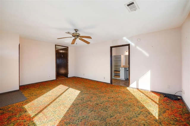 unfurnished room with ceiling fan and dark carpet