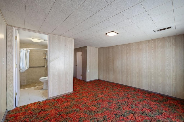 interior space featuring light carpet and wooden walls