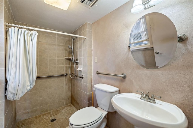 bathroom featuring sink, curtained shower, and toilet