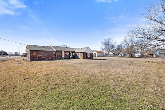 rear view of property featuring a lawn