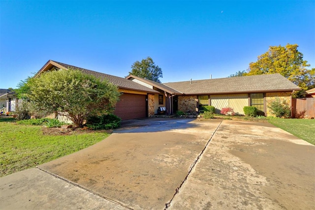 ranch-style house with a garage and a front lawn