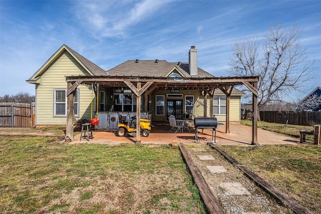 back of house featuring a lawn and a patio