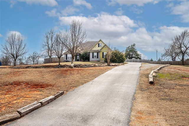 view of front facade with aphalt driveway and fence