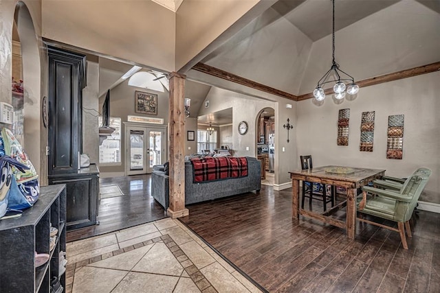 dining area featuring arched walkways, an inviting chandelier, wood finished floors, and baseboards