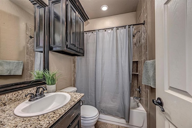 bathroom featuring shower / tub combo, a textured wall, vanity, and toilet