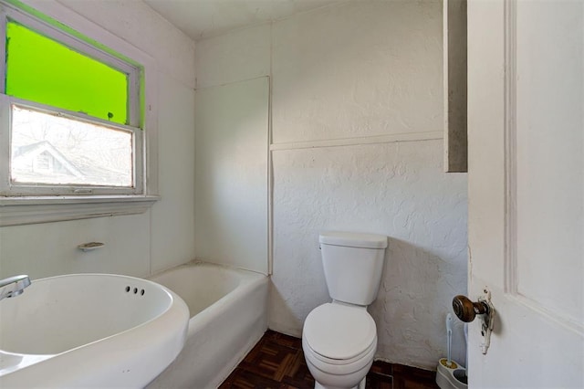 1801 E Madison St, Oklahoma City, OK 73111 - bathroom featuring toilet, parquet floors, and a bathing tub