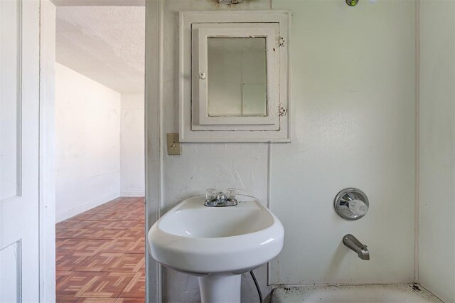 1801 E Madison St, Oklahoma City, OK 73111 - bathroom with sink, a textured ceiling, electric panel, and parquet flooring