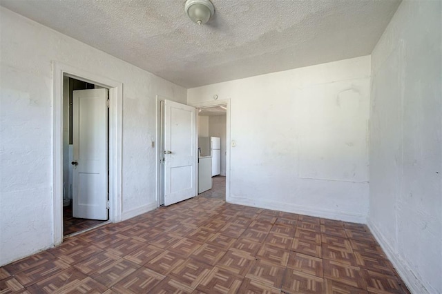 1801 E Madison St, Oklahoma City, OK 73111 - spare room with a textured ceiling and dark parquet flooring