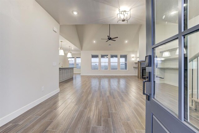 unfurnished living room featuring ceiling fan, high vaulted ceiling, and hardwood / wood-style floors