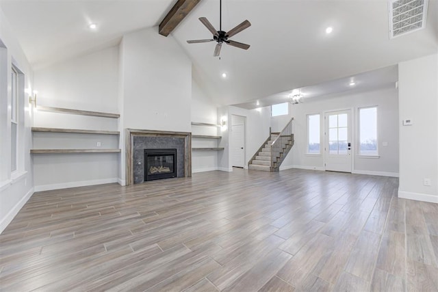 unfurnished living room featuring ceiling fan, beam ceiling, high vaulted ceiling, and light wood-type flooring