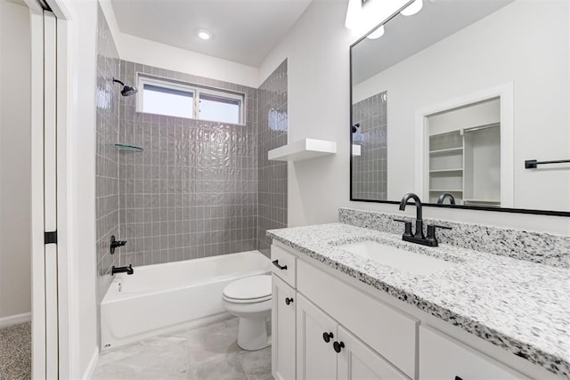 full bathroom with tiled shower / bath, vanity, and toilet