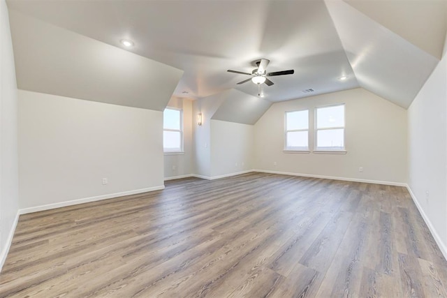 additional living space with hardwood / wood-style flooring, ceiling fan, and vaulted ceiling