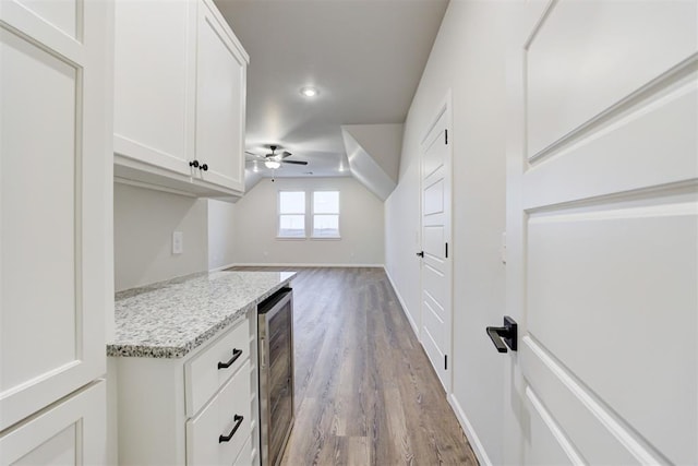 interior space featuring ceiling fan, beverage cooler, and light hardwood / wood-style flooring