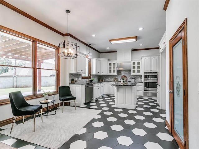 kitchen featuring hanging light fixtures, white cabinetry, a center island, and stainless steel appliances