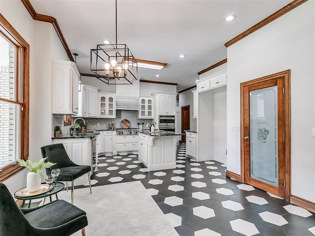 kitchen featuring pendant lighting, ornamental molding, white cabinets, and a kitchen island