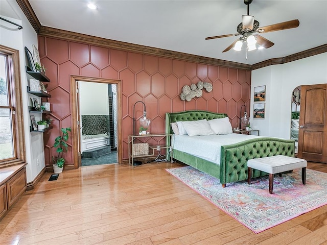 bedroom featuring crown molding, ceiling fan, light wood-type flooring, and ensuite bath