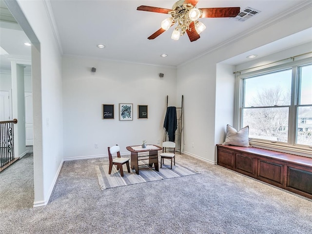 living area with ornamental molding, light carpet, and ceiling fan