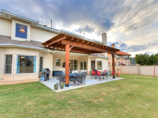 rear view of house featuring a patio area and a lawn