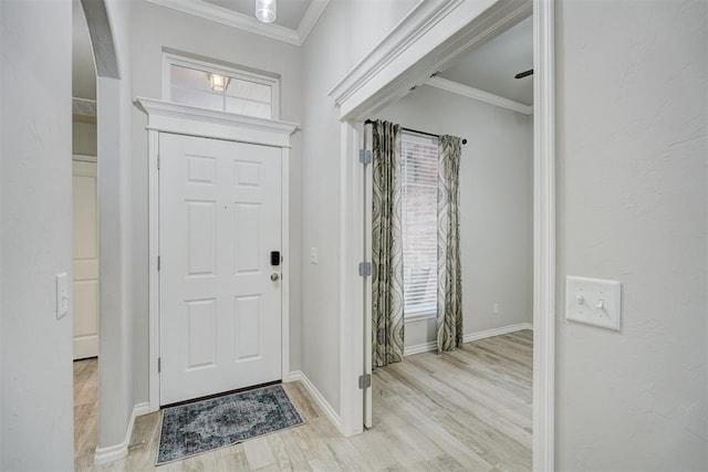 foyer with crown molding and light hardwood / wood-style floors