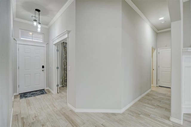 foyer entrance featuring crown molding and light wood-type flooring