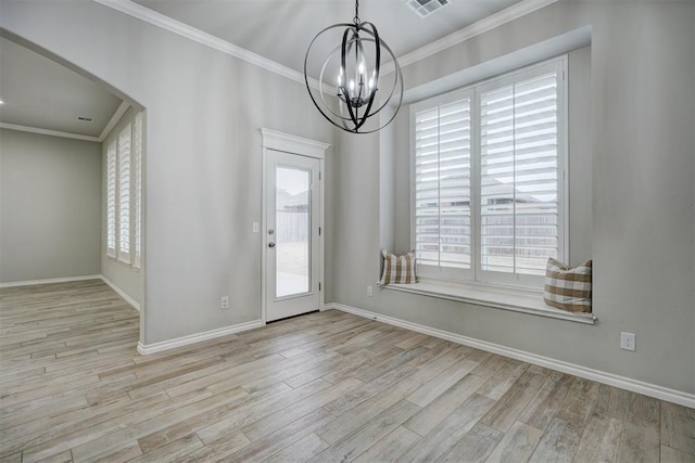 entrance foyer with an inviting chandelier, ornamental molding, and light hardwood / wood-style floors