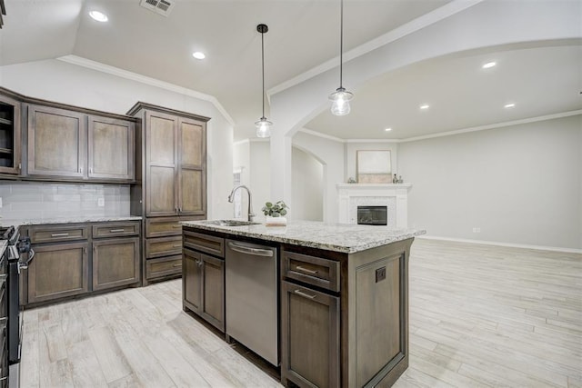 kitchen featuring appliances with stainless steel finishes, pendant lighting, sink, dark brown cabinetry, and a center island with sink