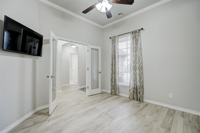 unfurnished bedroom with ornamental molding, ceiling fan, light wood-type flooring, and french doors