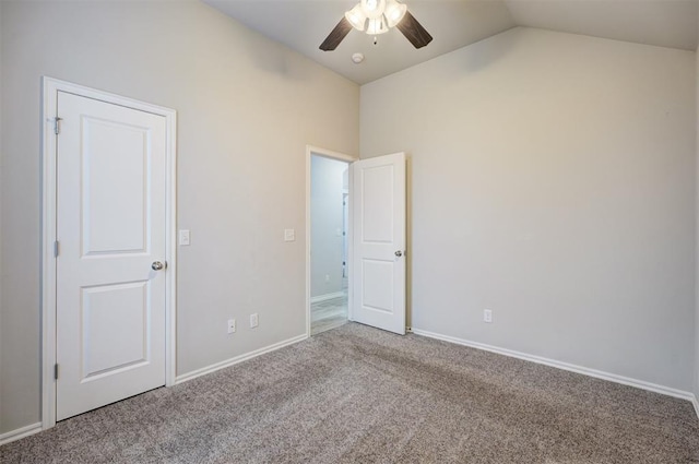 empty room with ceiling fan, carpet flooring, and vaulted ceiling