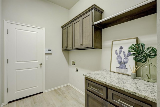 washroom with cabinets, washer hookup, hookup for an electric dryer, and light wood-type flooring