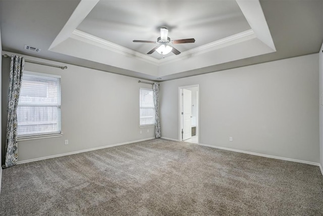 carpeted empty room featuring a raised ceiling, ornamental molding, and ceiling fan