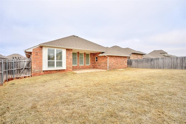 rear view of house with a patio area and a lawn