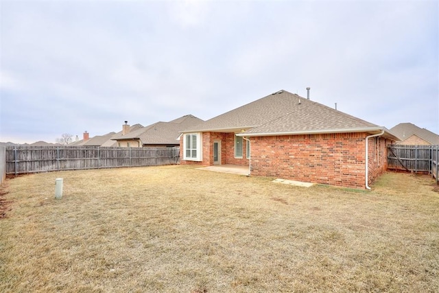 back of house with a yard and a patio