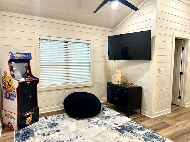 recreation room featuring lofted ceiling, hardwood / wood-style floors, and ceiling fan