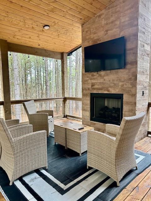 exterior space with wood ceiling and a large fireplace