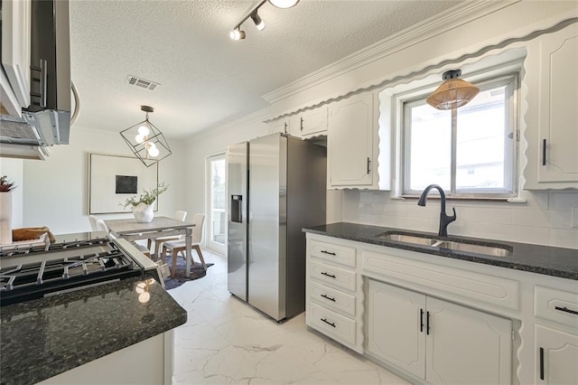 kitchen with appliances with stainless steel finishes, sink, dark stone countertops, white cabinets, and crown molding